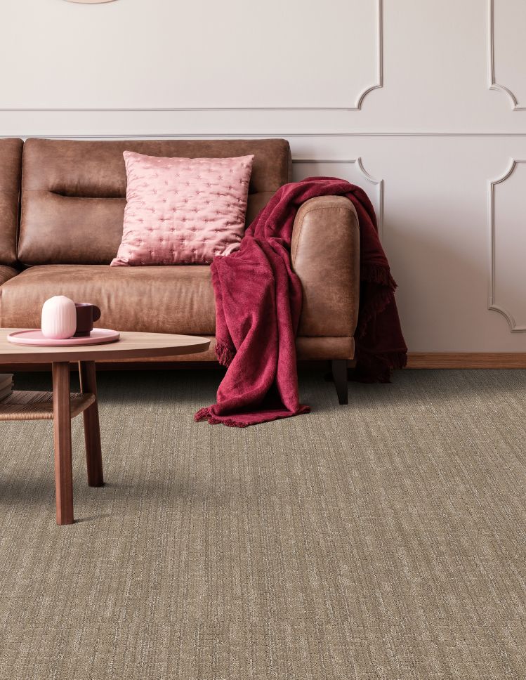 brown textured carpets in an Illinois living room with brown leather couch and pink accents